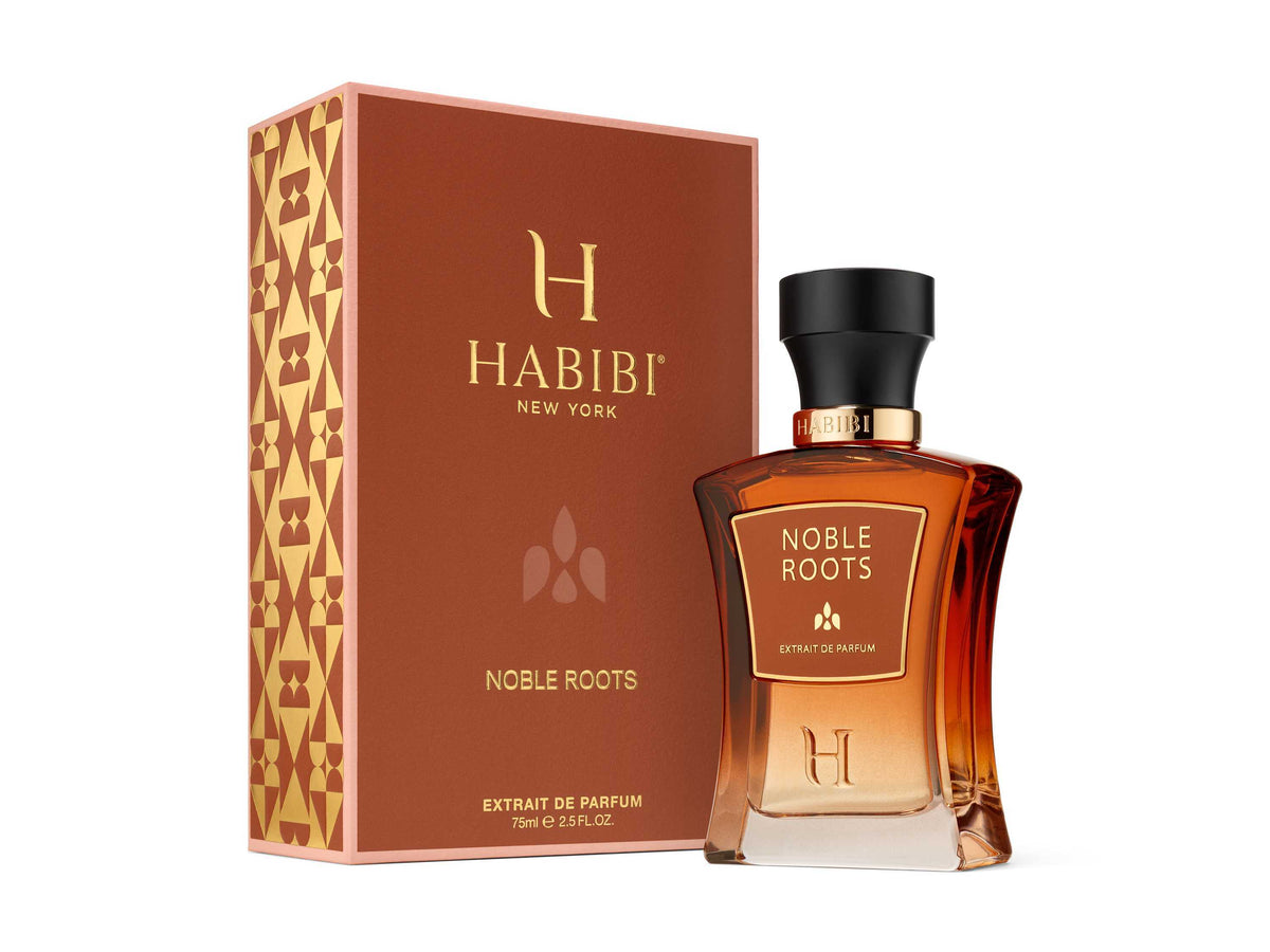 Noble Roots Extrait de Parfum by HABIBI New York, amber-red glass bottle with black cap resting on tan leather.
