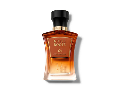 Noble Roots Extrait de Parfum by HABIBI New York, amber-red glass bottle with black cap resting on tan leather.