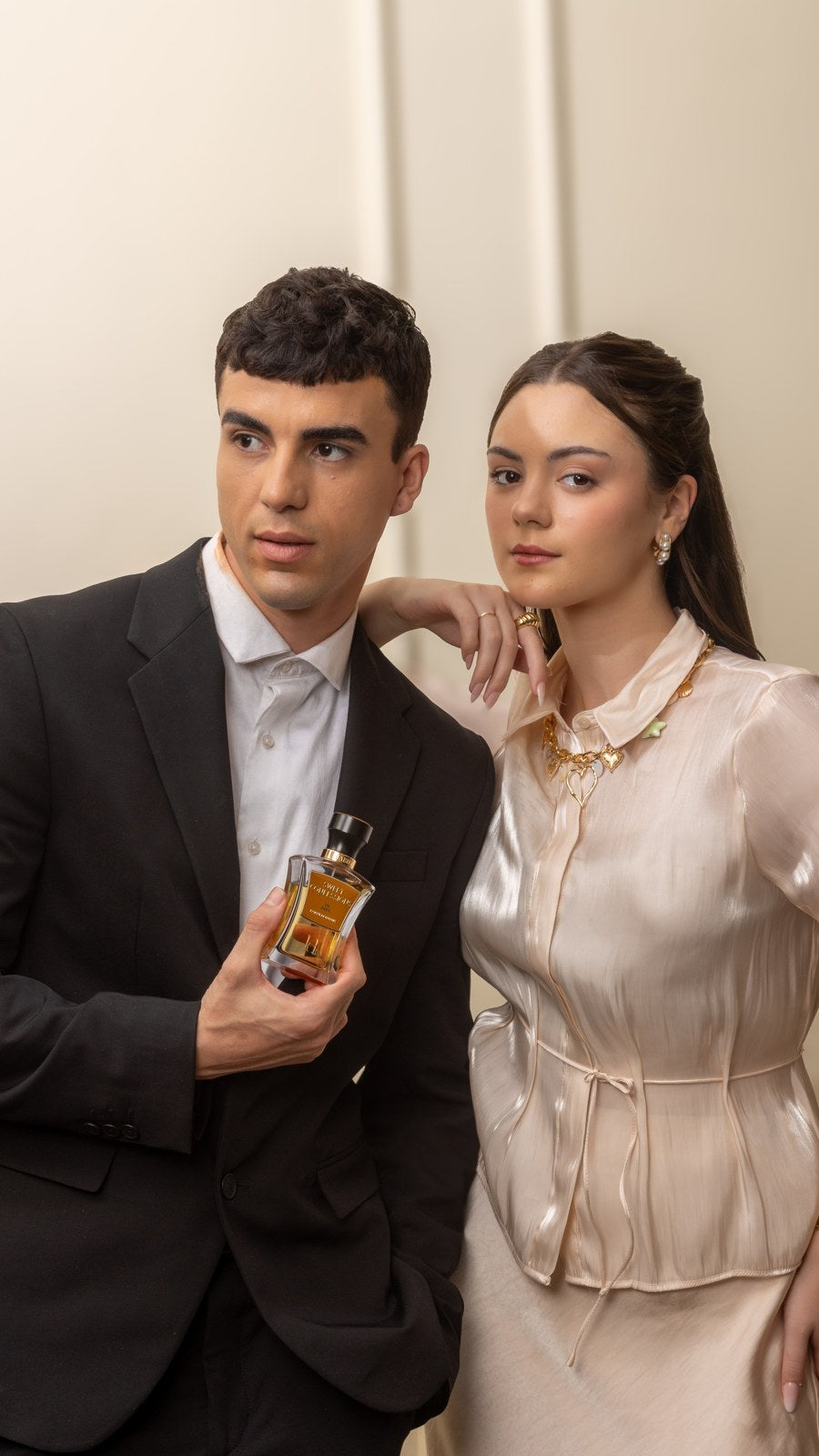 A couple close together holding a HABIBI bottle
