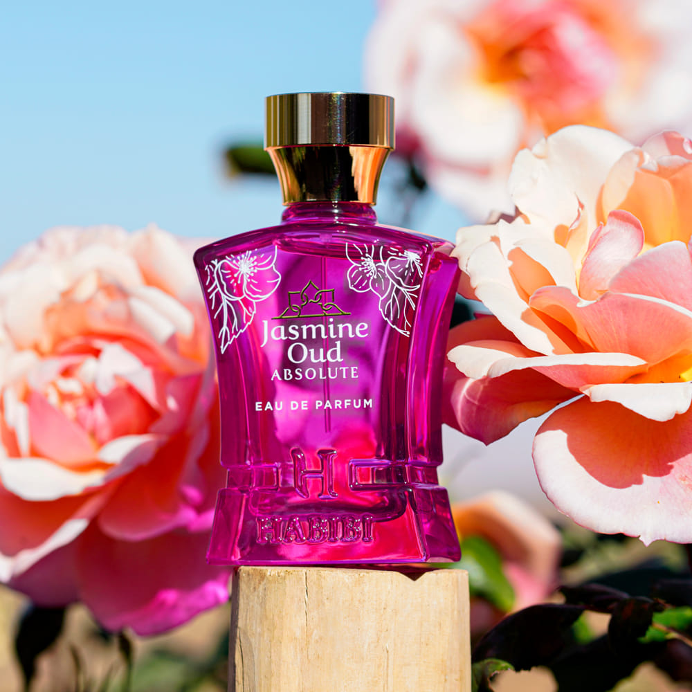 Jasmine Oud Absolute fragrance bottle with floral background.